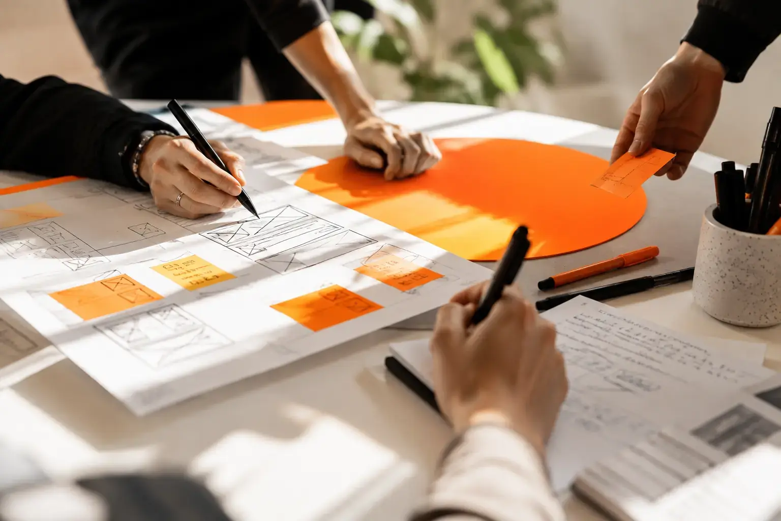 Zwei Personen skizzieren Wireframes einer Website
